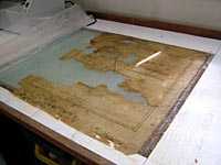 A damaged document undergoes treatment in the conservation studio.