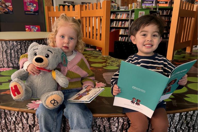 Children in library with helpful bear