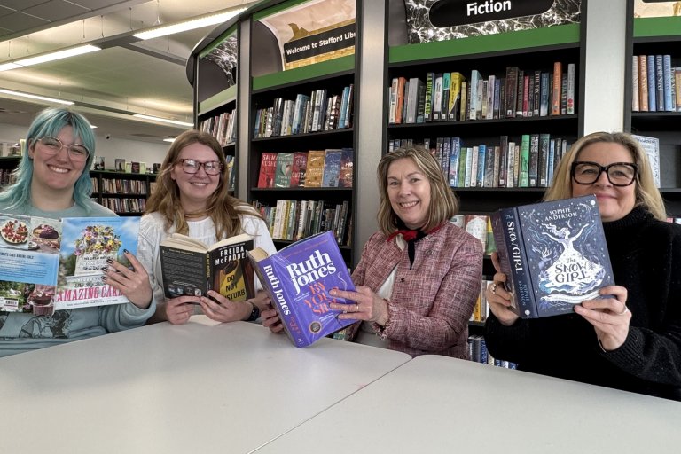 Library staff holding their recommended books for Easter reading