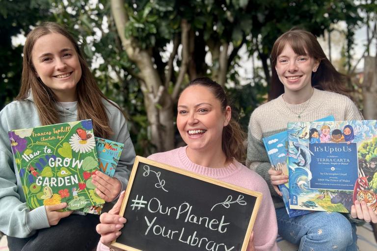 Library staff with green-themed books