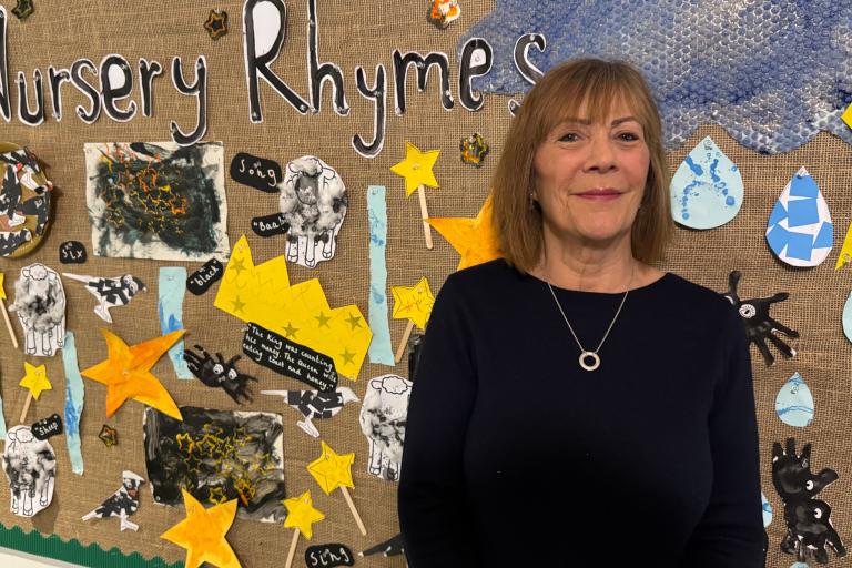 Janet Higgins in a school by children's art