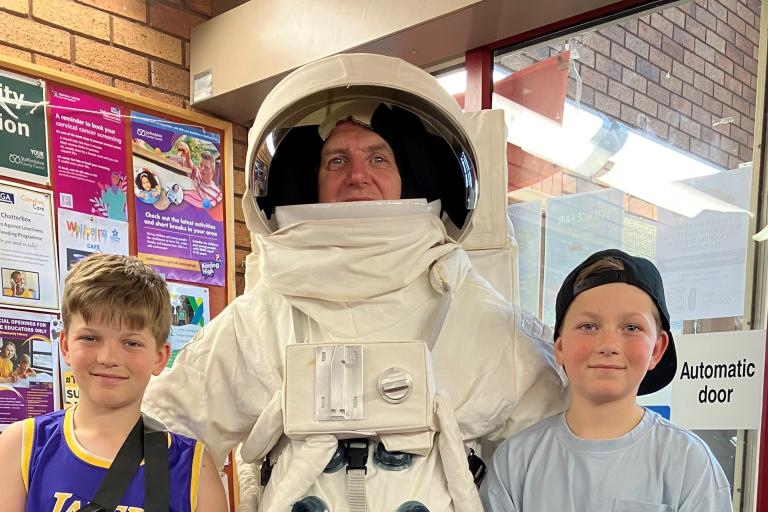 man in astronaut outfit with two children