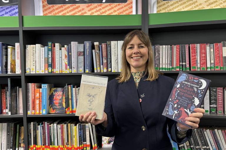 Hayley Coles holding poetry books in library