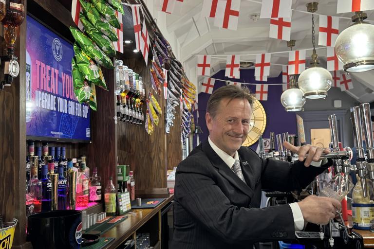 Martin Murray pouring a pint with World Cup England flag bunting above