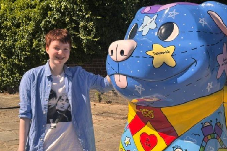 a person stood next to a blue staffy sculpture