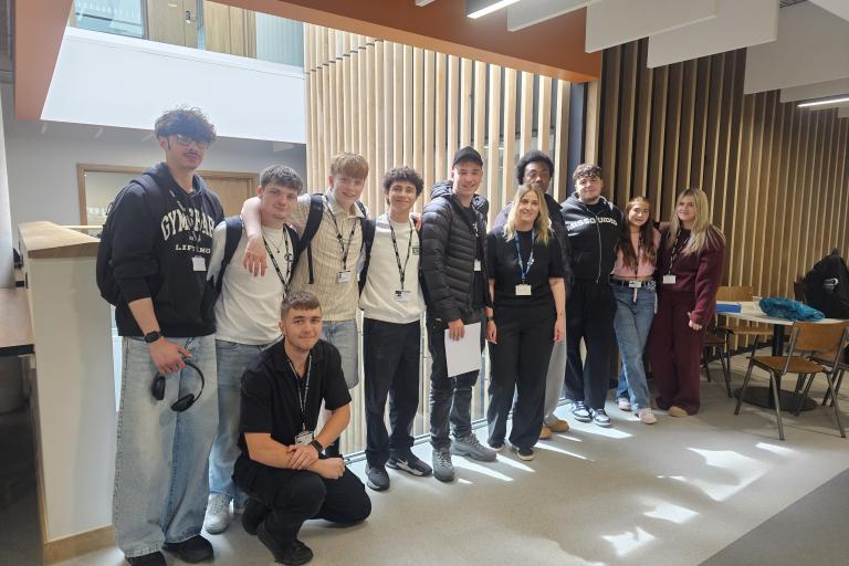 Eleven casually dressed 17-18 year old students lined up, smiling at the camera.