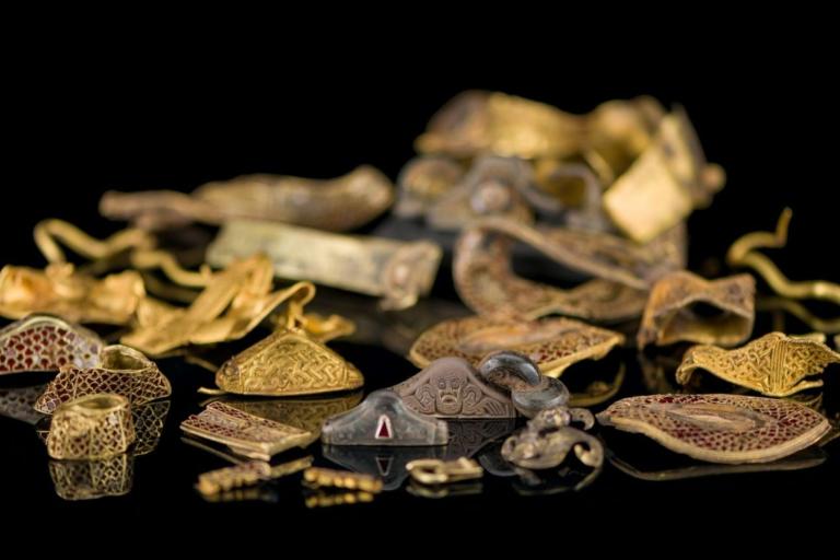 A collection of Anglo-Saxon gold and silver, including sword fittings, helmet fragments and other military related items.