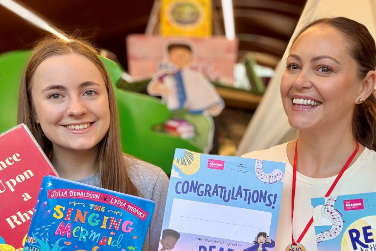 two library staff members holding musically themed books
