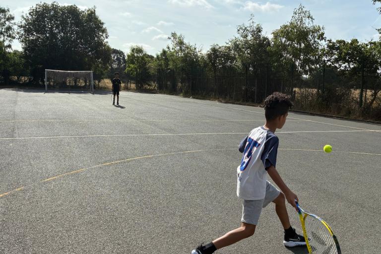Boys playing tennis at the Family Hub