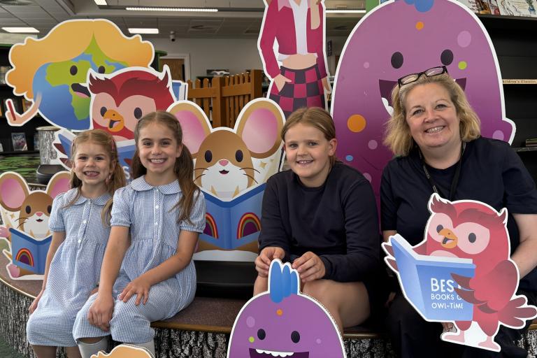Children with their cartoon character cardboard cutouts in library