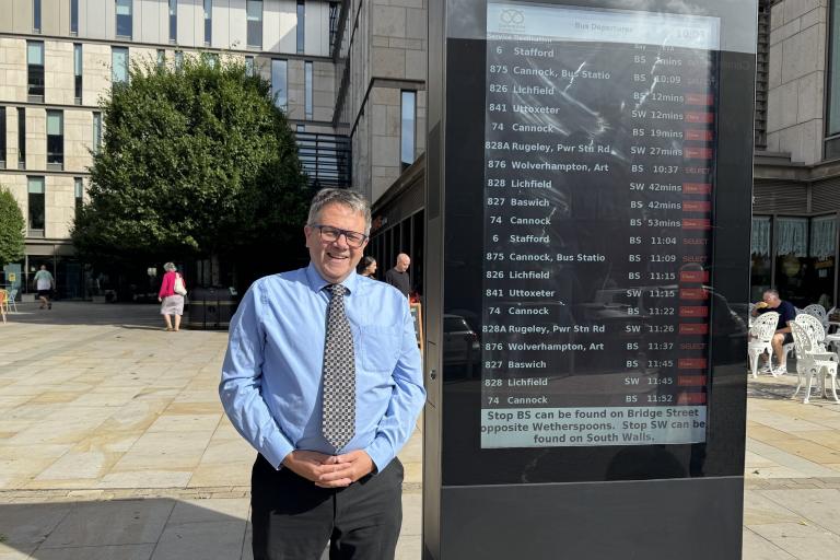 Andrew Mynors standing next to bus times totem