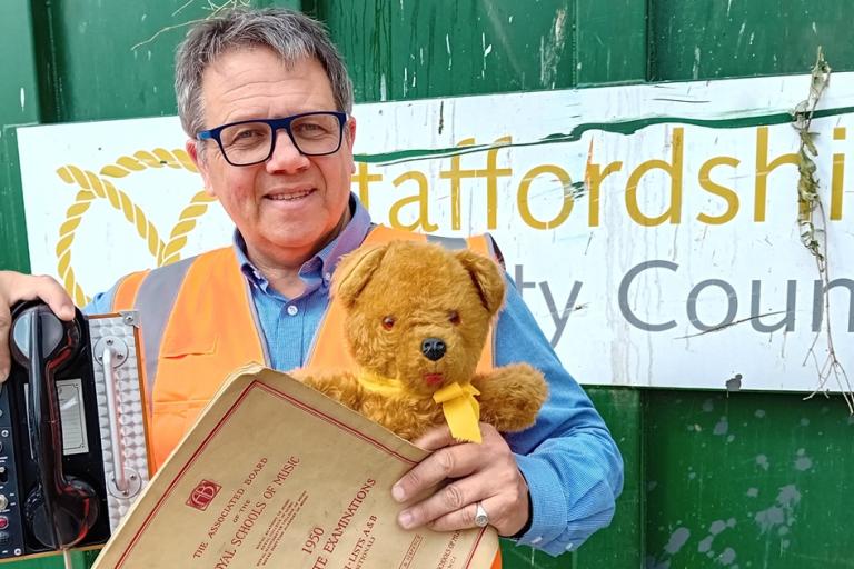 Andrew Mynors holding items at household waste recycling centre
