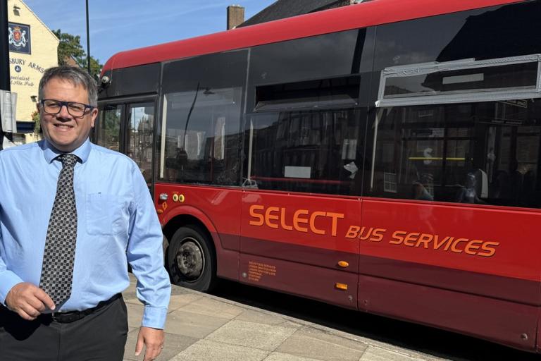 Andrew Mynors standing by bus