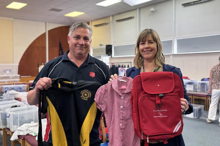 David Cox and Hayley Coles holding up donated school uniform