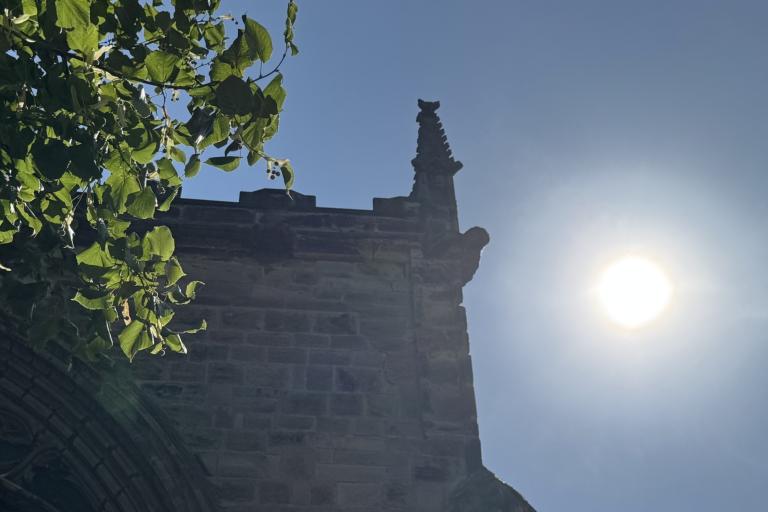 blazing sun next to church spire