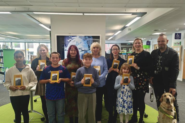 Stafford Library's short story competition winners stand together with their awards