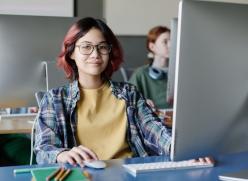 Girl sitting at a desk looking at a computer