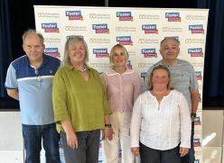 Foster carers stood in front of promotional banner
