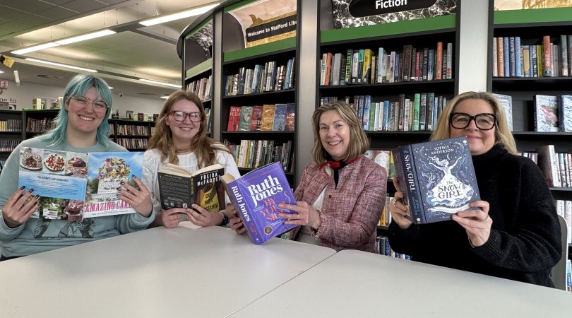 Library staff holding their recommended books for Easter reading