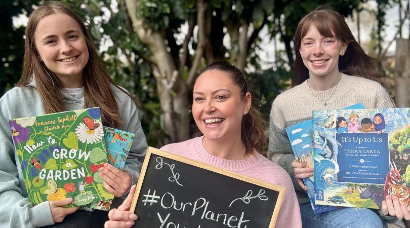 Library staff with green-themed books