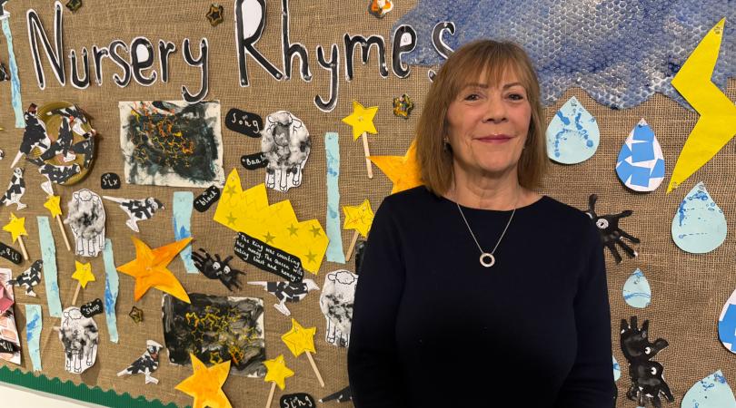 Janet Higgins in a school by children's art