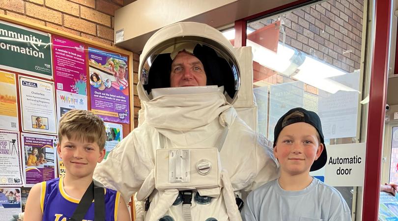 man in astronaut outfit with two children