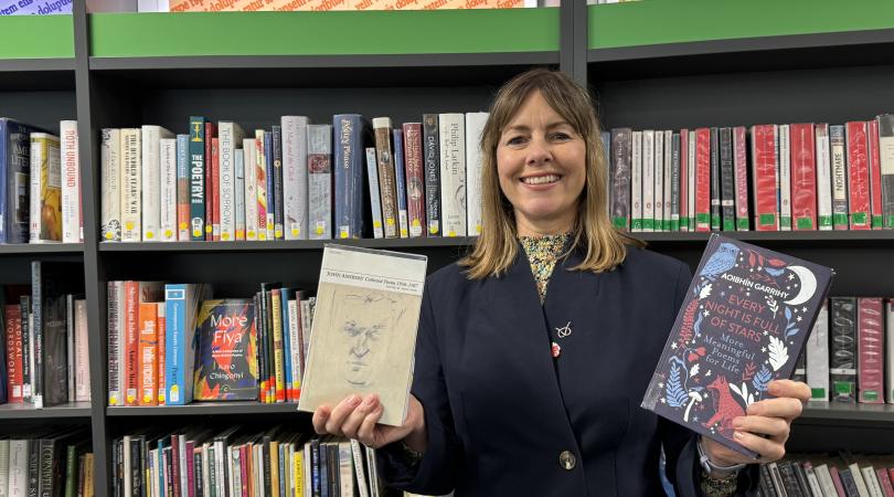 Hayley Coles holding poetry books in library