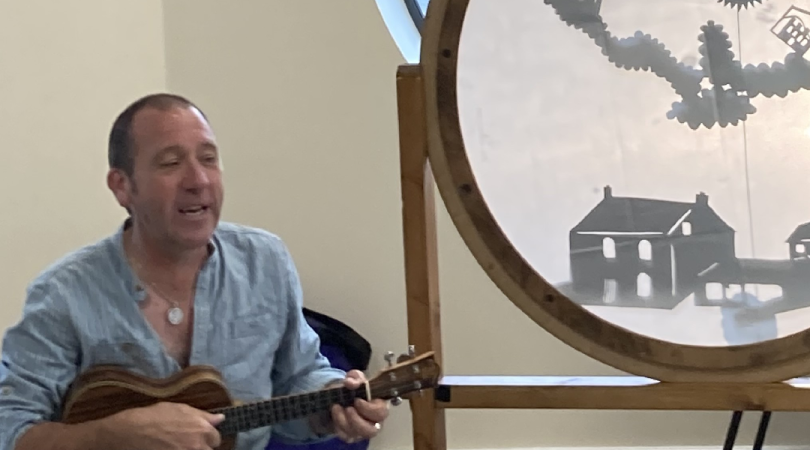 Man playing guitar next to shadow puppets at Moorlands Family Hub