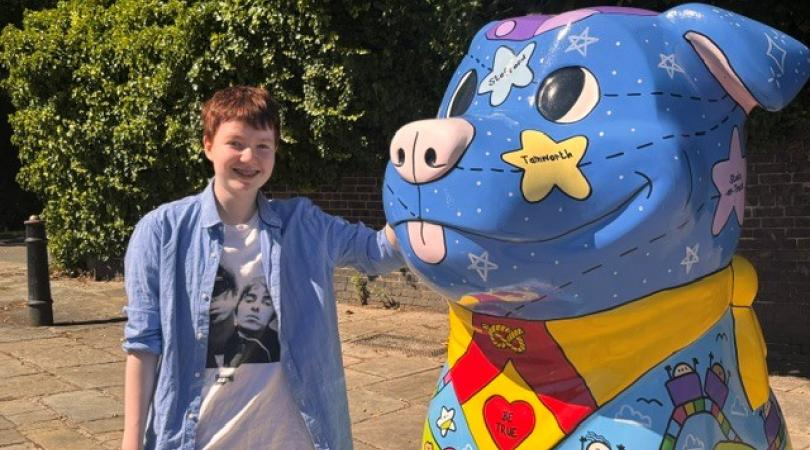 a person stood next to a blue staffy sculpture