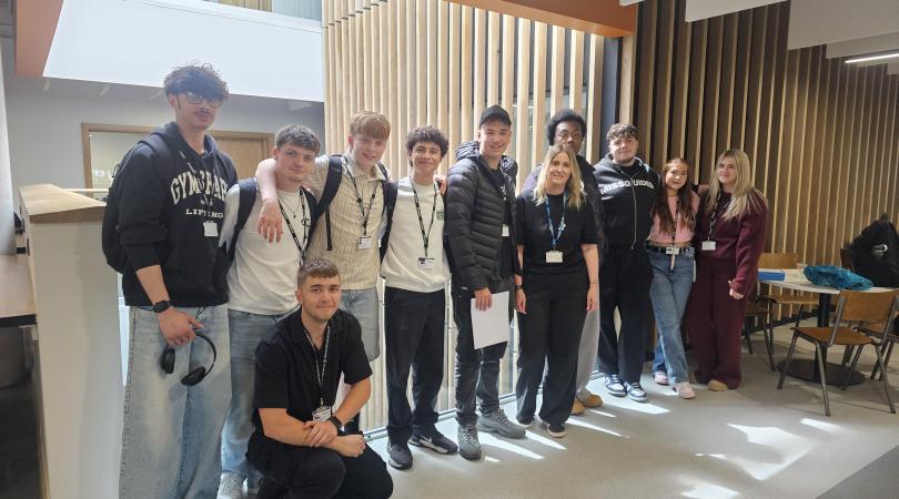 Eleven casually dressed 17-18 year old students lined up, smiling at the camera.