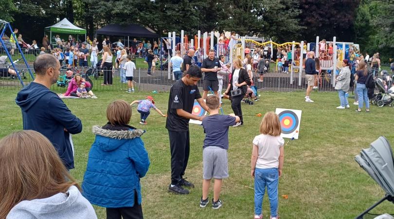 families taking part in various activities in park