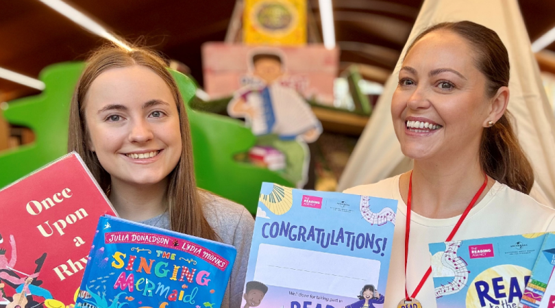 two library staff members holding musically themed books