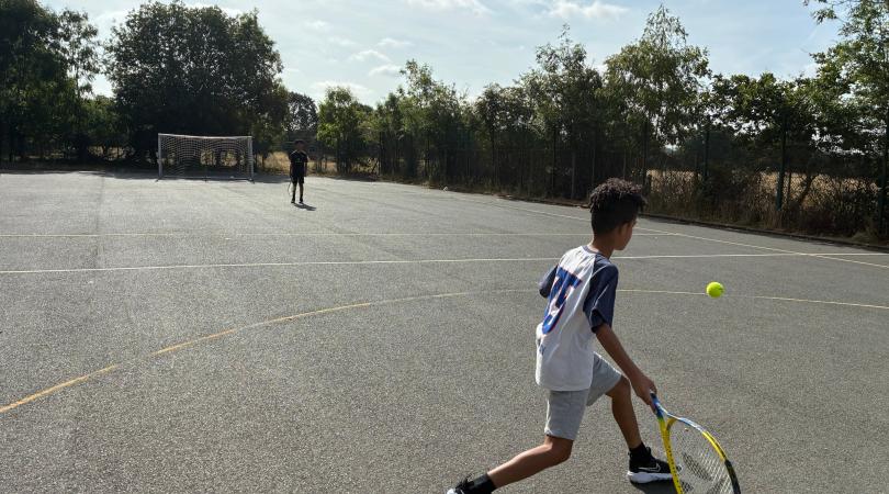 Boys playing tennis at the Family Hub