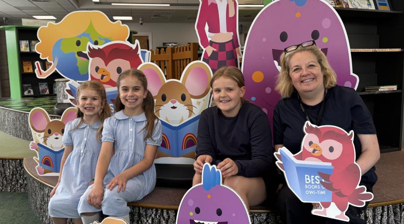 Children with their cartoon character cardboard cutouts in library