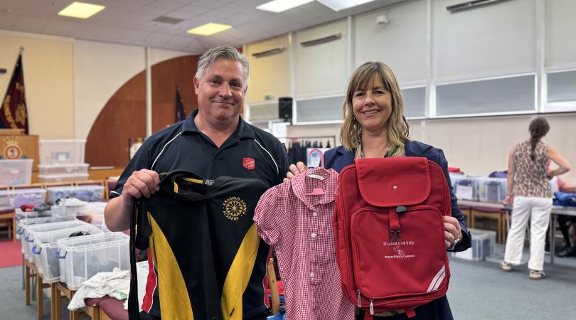 David Cox and Hayley Coles holding up donated school uniform