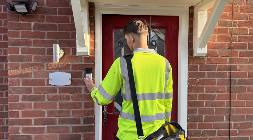 A trader in a yellow vest knocking on a front door