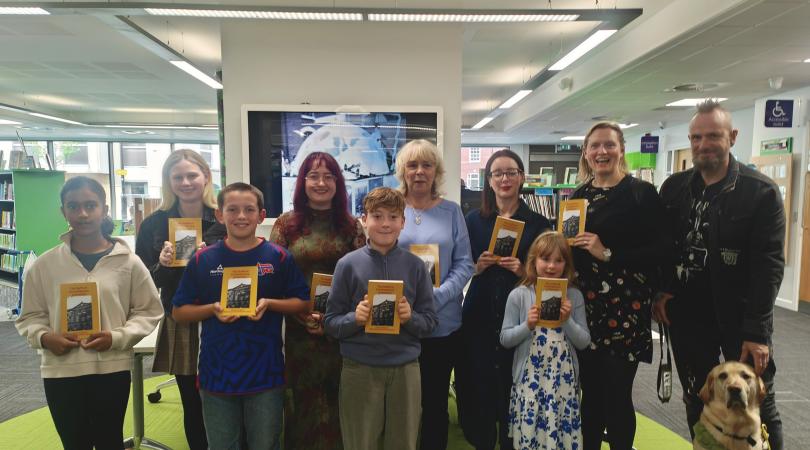 Stafford Library's short story competition winners stand together with their awards