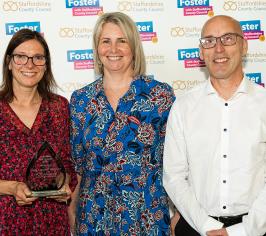 Images contains 2 foster carers being presented with their fostering award